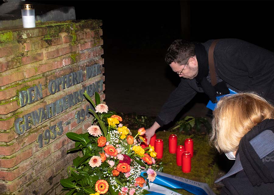Kranzniederlegung 1: Teilnehmer des Gedenktags stellen Kerzen ab.