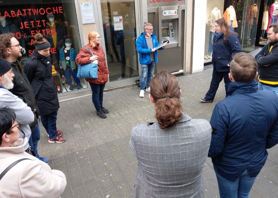 Die Gruppe vom "Rundgang gegen das Vergessen" rund um einen Stolper-Stein in der Trierer Innenstadt