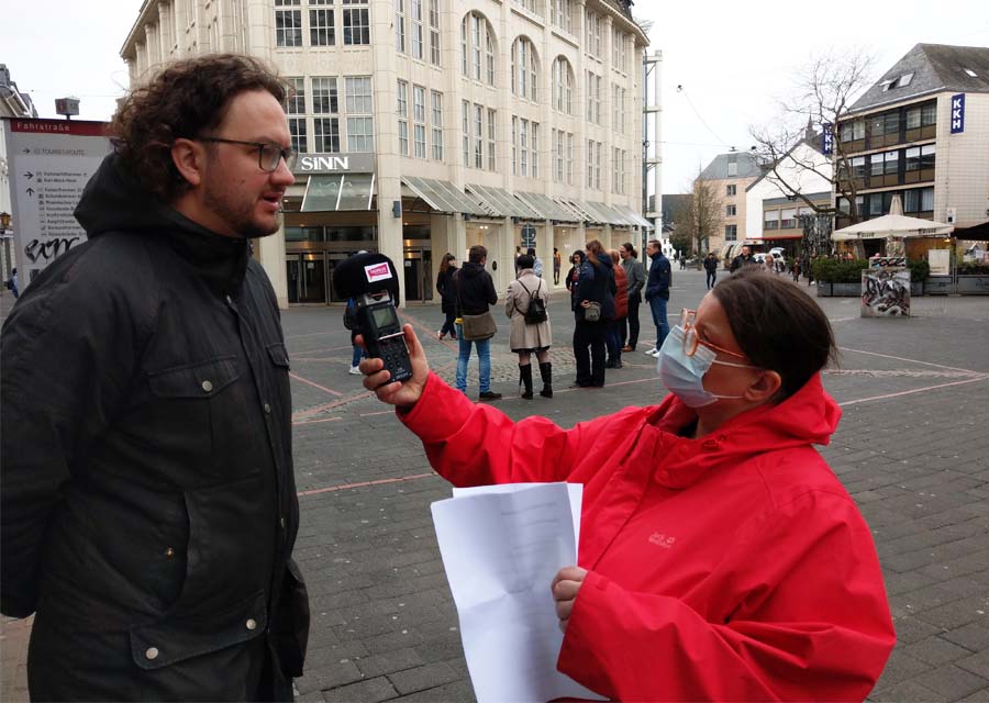 TACHELES-Reporterin Beate Macher interviewt Lucas Keuser vom Fanprojekt Trier. Im Hintergrund die Gruppe des Rundgangs.