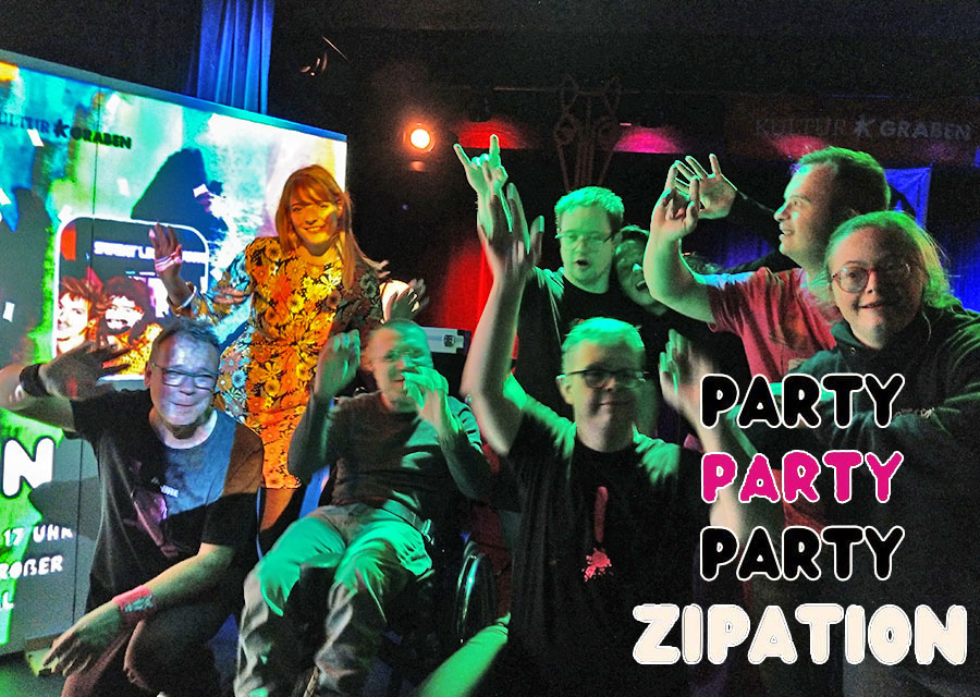 TACHELES-Patrick jubelt mit Musikern in die Kamera, dunkle, bunte Partybeleuchtun, links eine bunte Leinwand. Schrift: Party Party Party Zipation. Titelbild