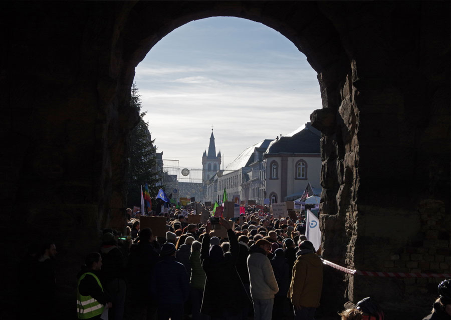 Blick auf Demonstrierende in der Trierer Innenstadt durch die Porta Nigra hindurch