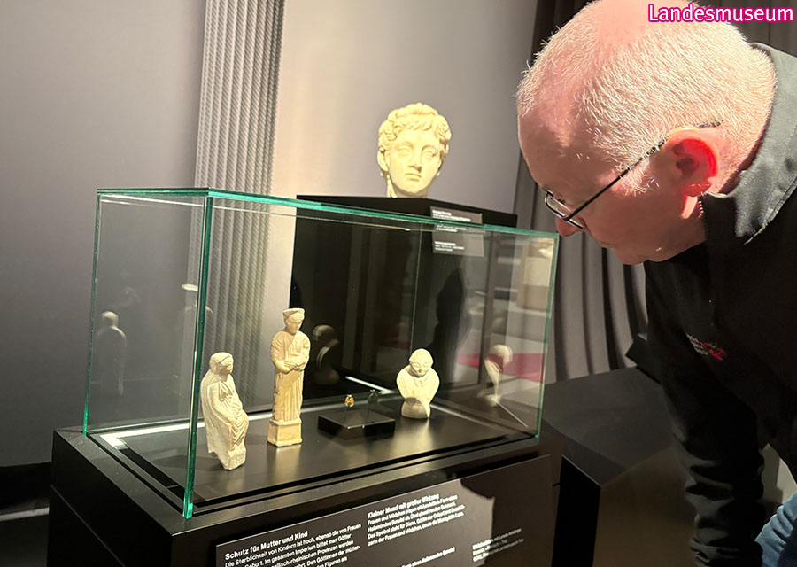 Michael schaut Ausstellungsstücke in einem Glaskasten an