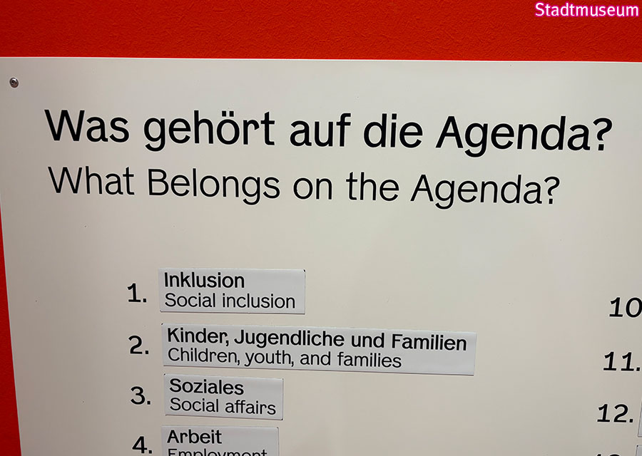 Schild: Was gehört auf die Agenda? Auf Platz 1 und 2 von Besuchern geklebt: Inklusion und Barrierefreiheit