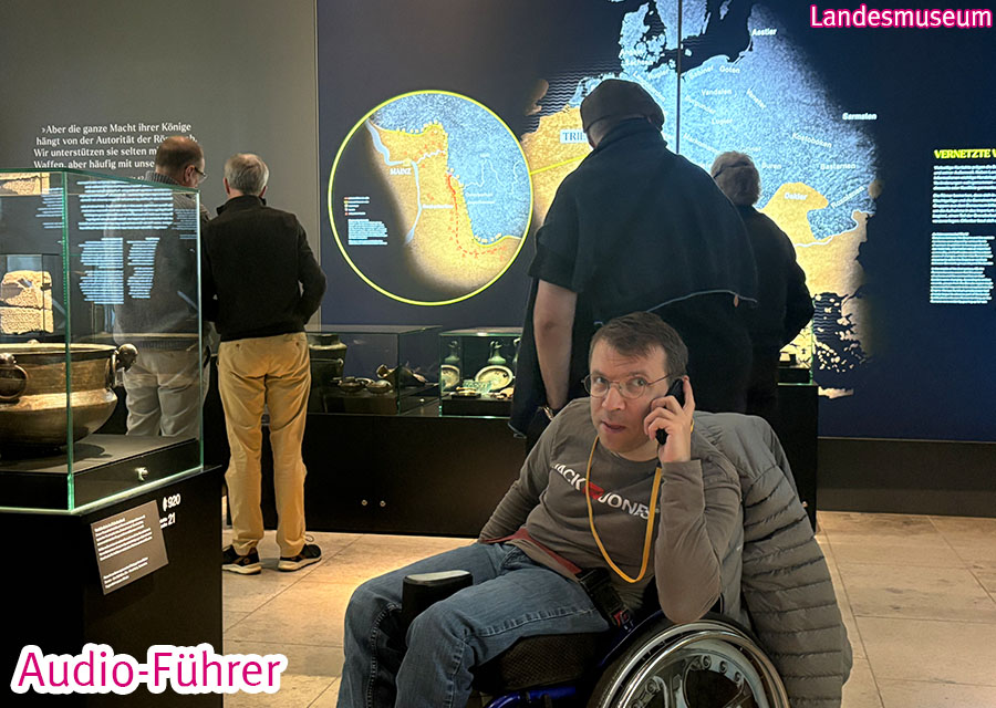 Patrick mit Audioguide in einem Ausstellungsraum