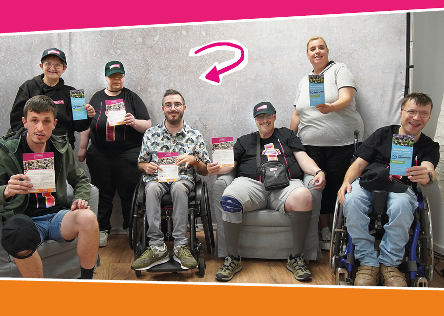 Sechs Reporter und Reporterinnen von TACHELES und Herr Laubenthal, der Netzwerkkoordinator vom Projekt „Inklusion vor Ort“ der Lebenshilfe Sankt Wendel sind vor einem hellgrauen Hintergrund. Herr Laubenthal und Patrick von TACHELES sitzen in Rollstühlen. Alle halten TACHELES Flyer in den Händen. Ein linker Pfeil zeigt auf Herrn Laubenthal. Die Stimmung wirkt freundlich und entspannt. Das Bild ist oben und unten eingerahmt von pinken und orangen Farbflächen.